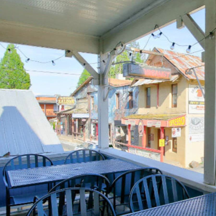 View from a balcony overlooking a street lined with rustic shops and buildings.